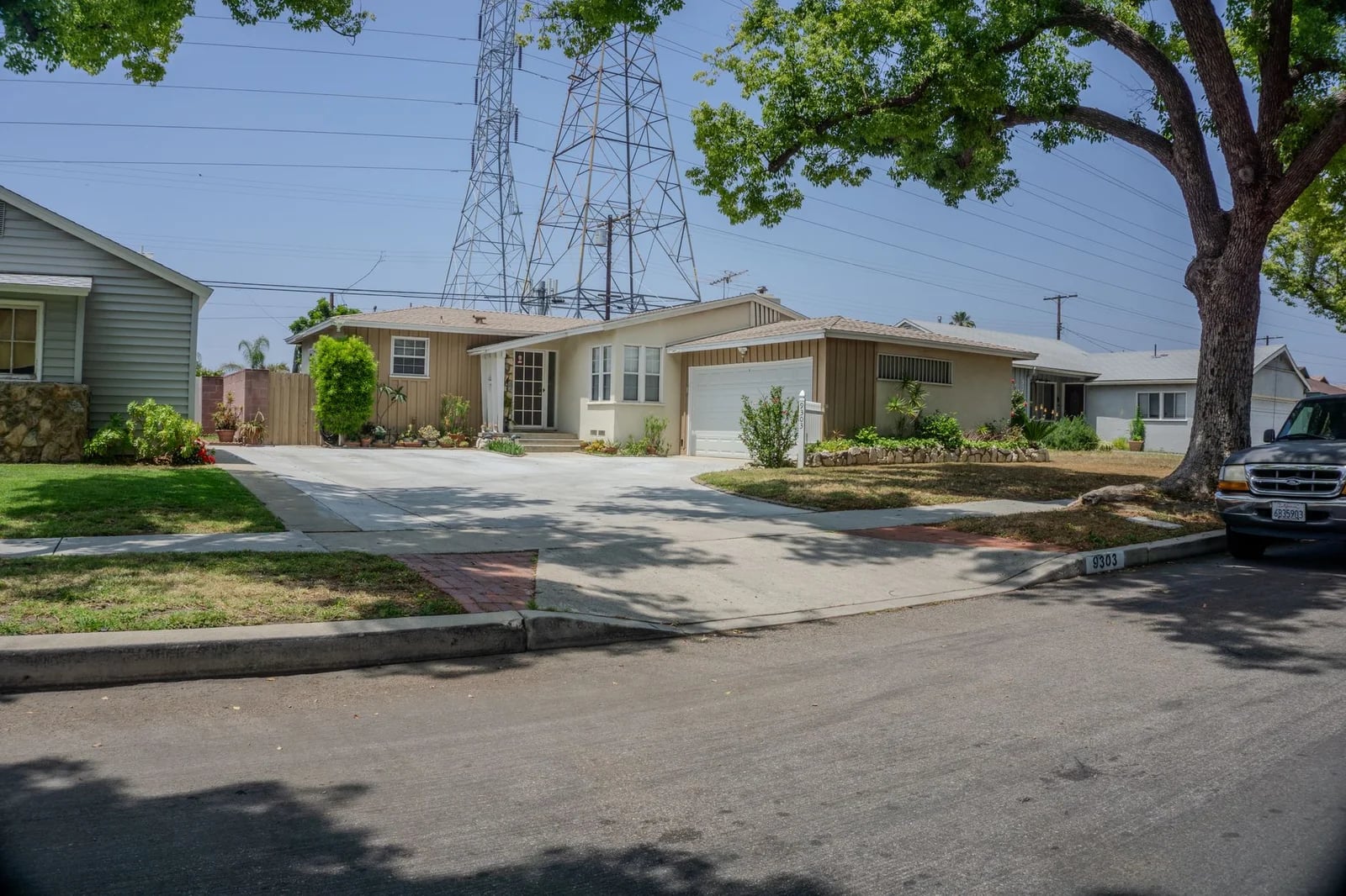Charming suburban street with mid-century homes and lush greenery on a sunny day.